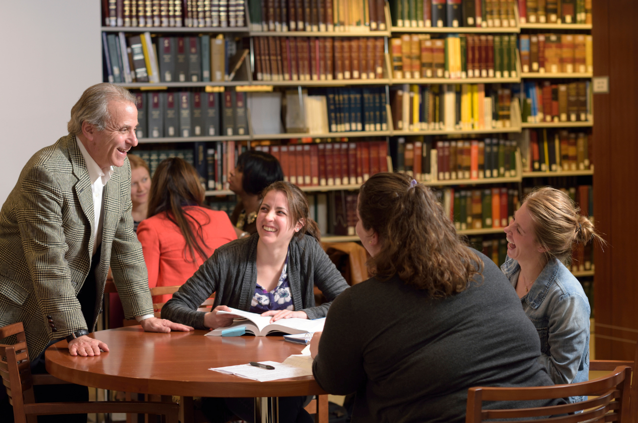 Paralegal professor and students at a table in a law library