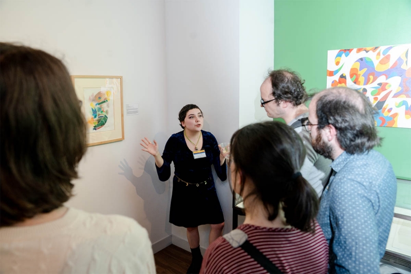 A woman talking to guests at an exhibit