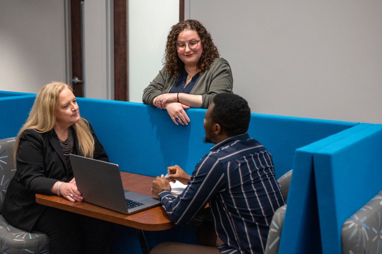 CSO692_20250415_1262_GradStudents Two career center staff members speakign with a student.