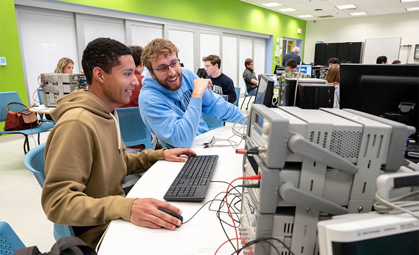 Bachelor of Science in Computer Engineering Two students sit at a desk with a computer