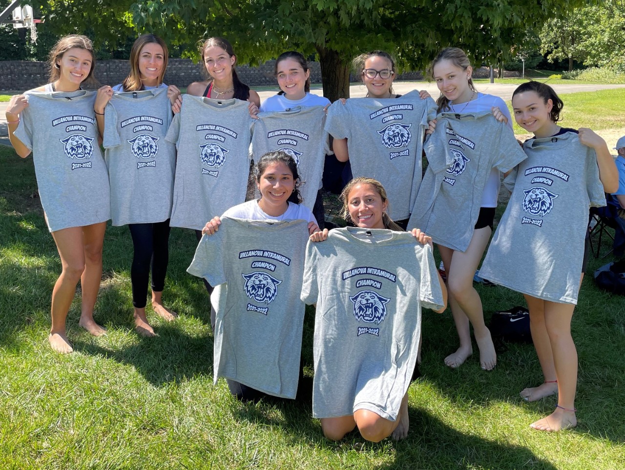 Female students posing for sand volleyball champion photo