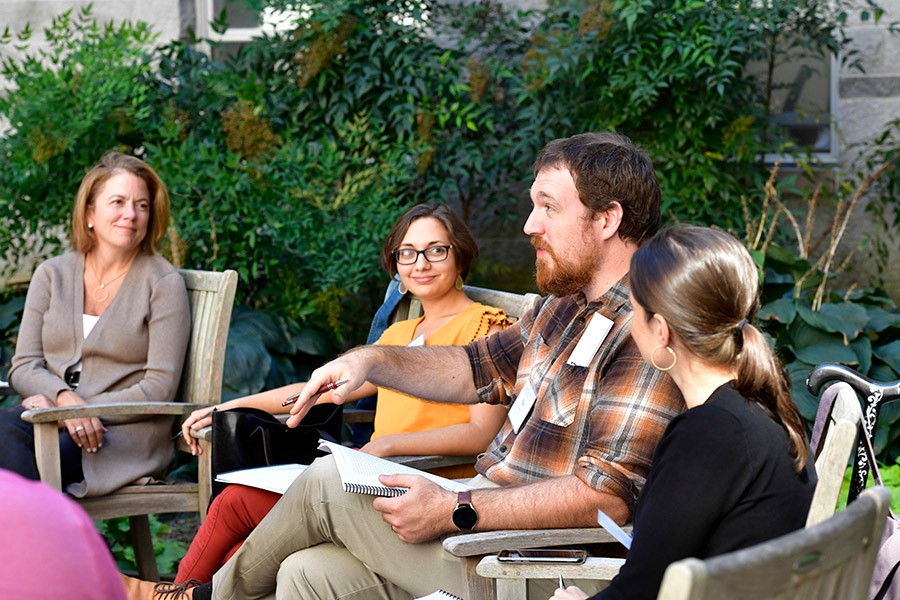 Humanities alumi and faculty sitting outside talking. Humanities alumi and faculty sitting outside talking.