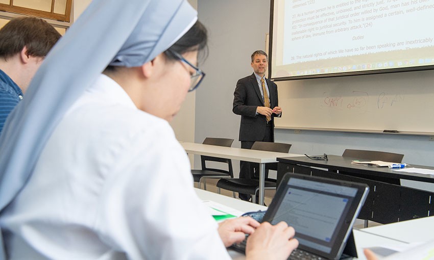 Graduate theology students taking notes in class image of students taking notes in class