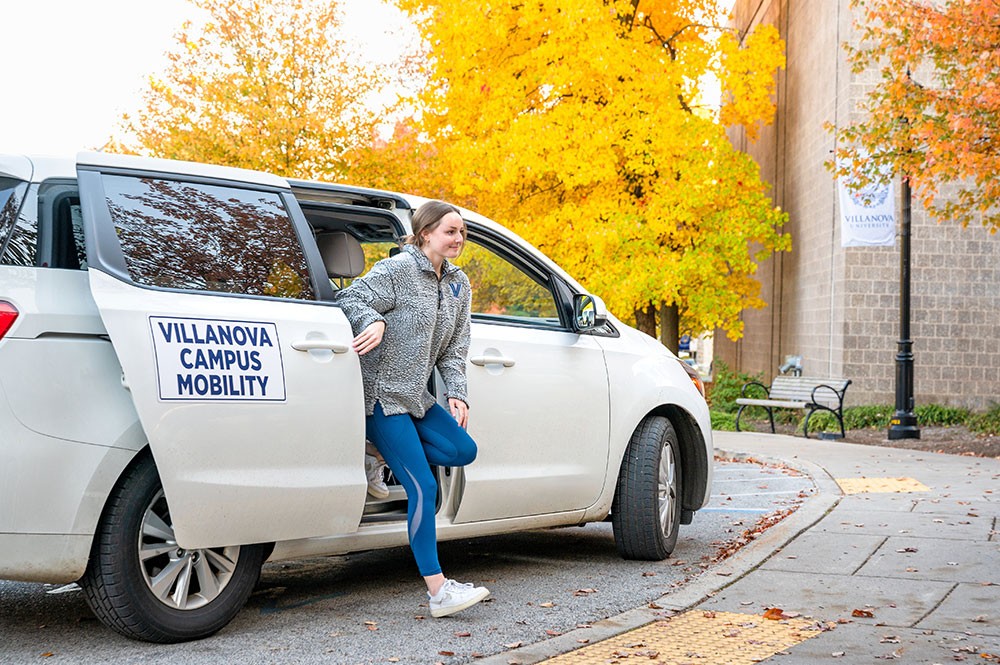 PSX318_20211109_0337 Female student stepping out of campus mobility car