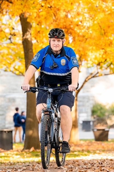 PSX318_20211109_0203 Public safety officer biking through campus
