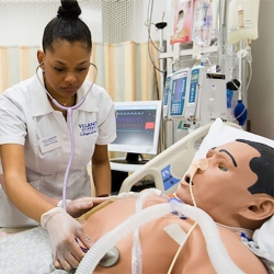 simulation-center Nursing student using stethoscope on mannequin chest