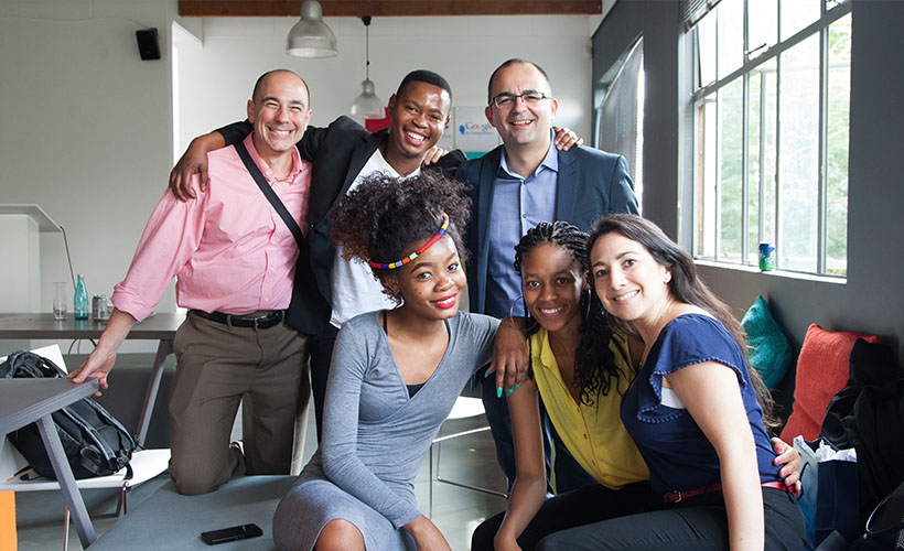 A group of EMBA students smile together.