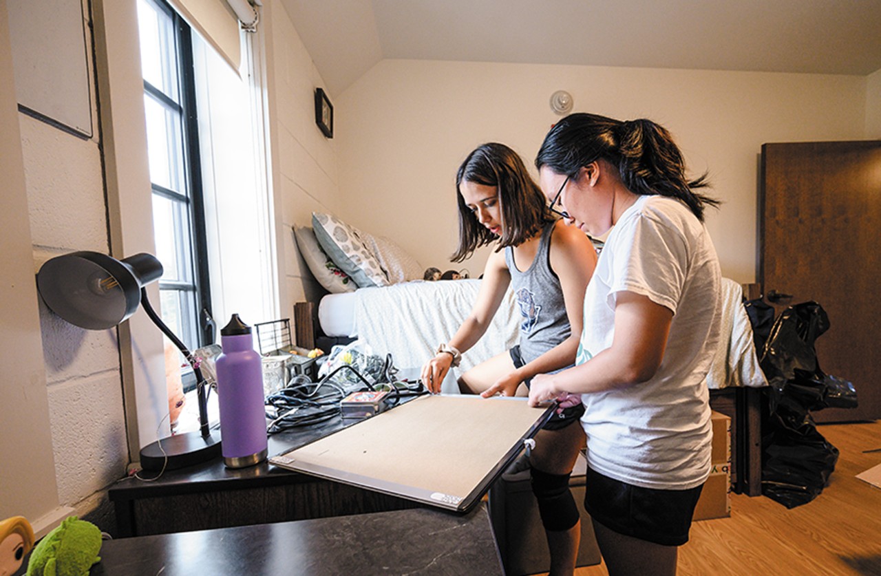 student Kaleigh Brendle, who is visually impaired, smiles and stands holding her cane