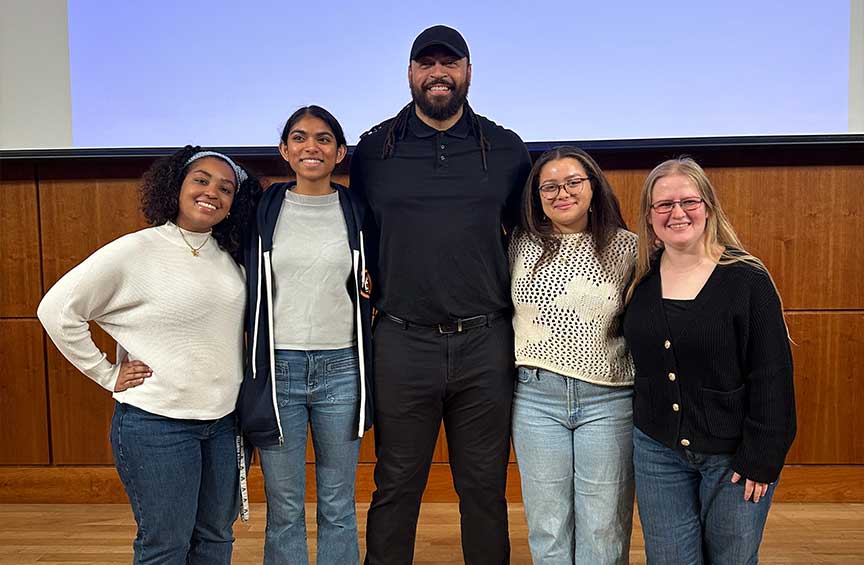 Hunger and Homelessness Awareness Week keynote speaker Garry Gilliam Jr. poses for a photo with four women.